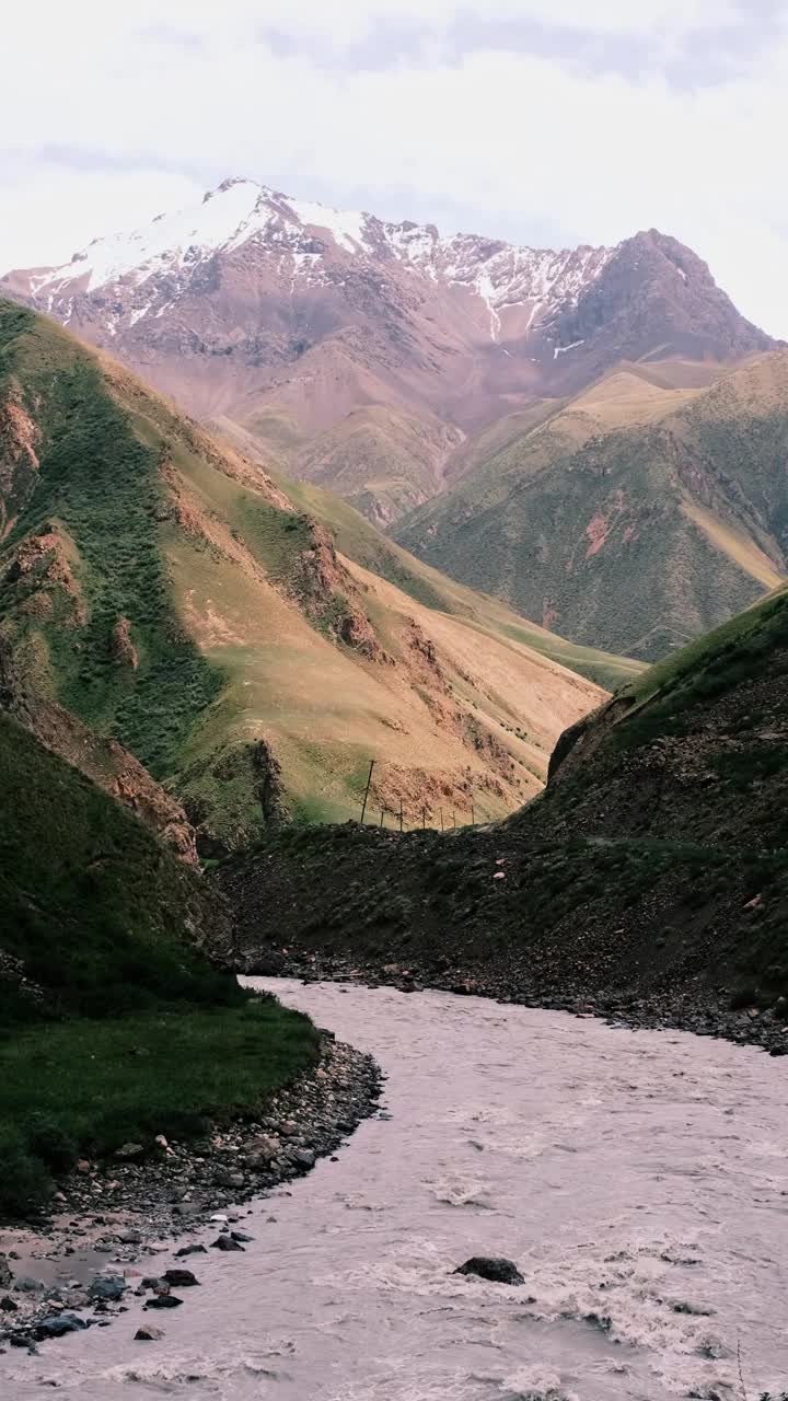 云下的高地河谷。背景是白雪皑皑的山脊视频素材