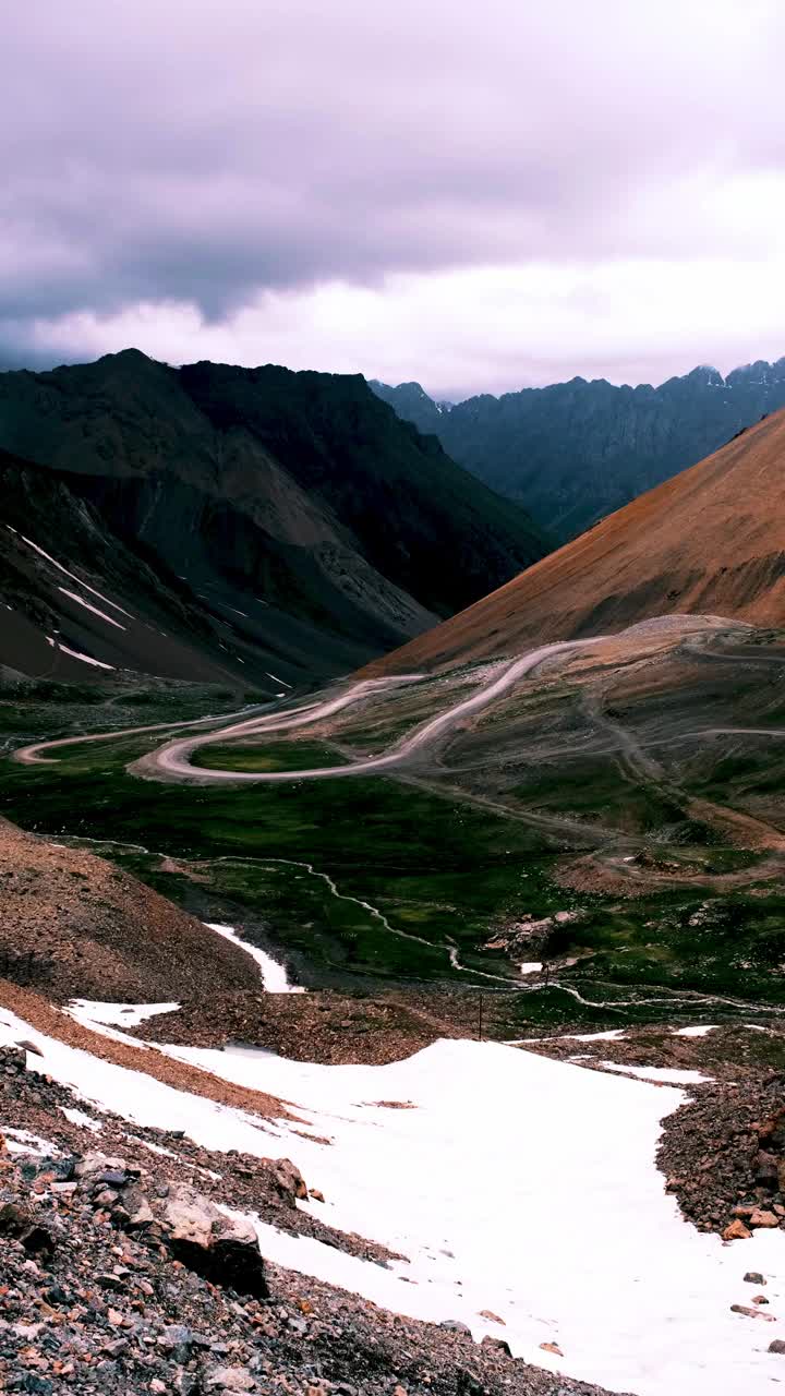 蜿蜒的道路穿过山口，阴沉的天空下，山间风暴视频素材