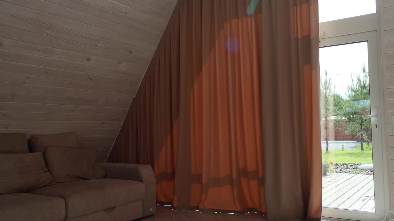 现代房子里的女人正拉开大窗帘。视频下载