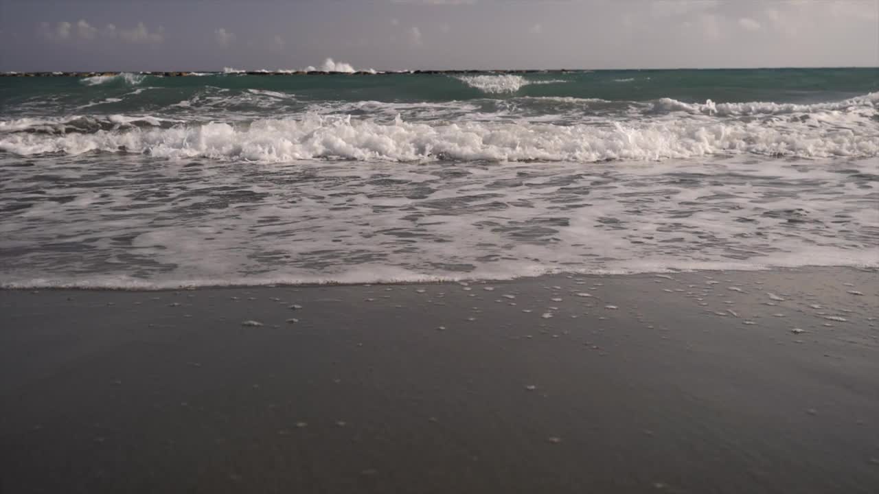 海浪轻轻地拍打着沙滩的沙滩岸，一种宁静的海边气氛视频素材