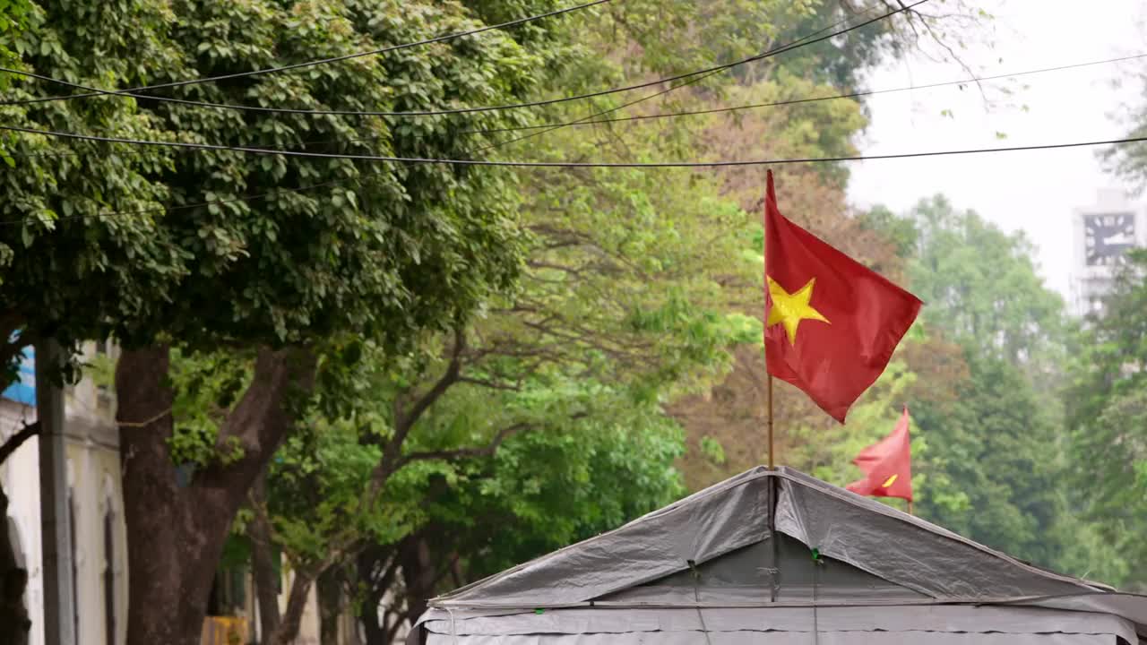 大帐篷里装饰着一面红色的越南国旗，与树木随风飘扬视频下载