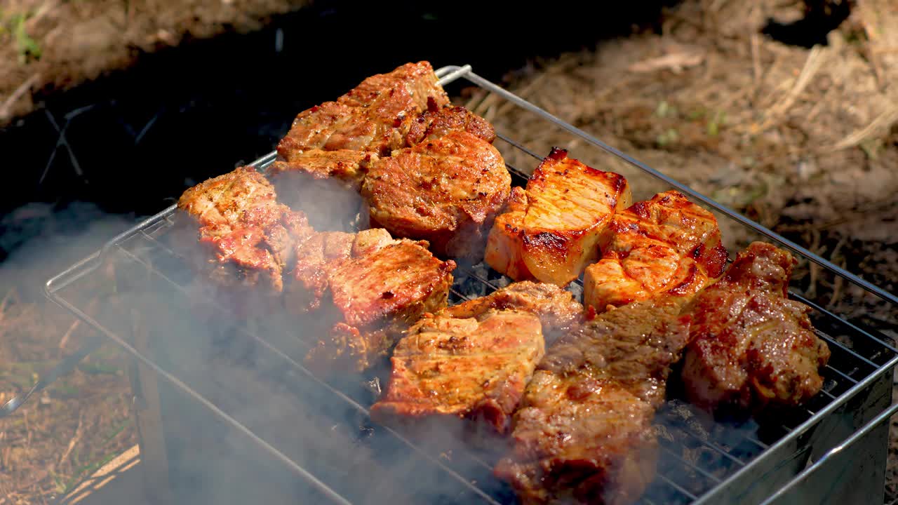 烤肉。各种肉块、牛排和鸡肉在热烤架上滋滋作响视频素材