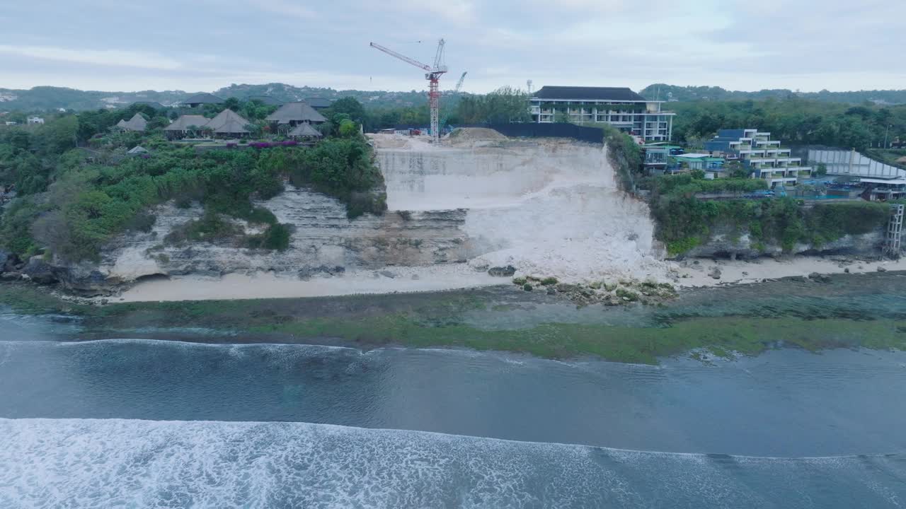 在印度尼西亚乌鲁瓦图岛巴厘岛的Bingin海滩，黄金时间日落与退潮礁石，过度开发的悬崖崩塌无人机视频素材