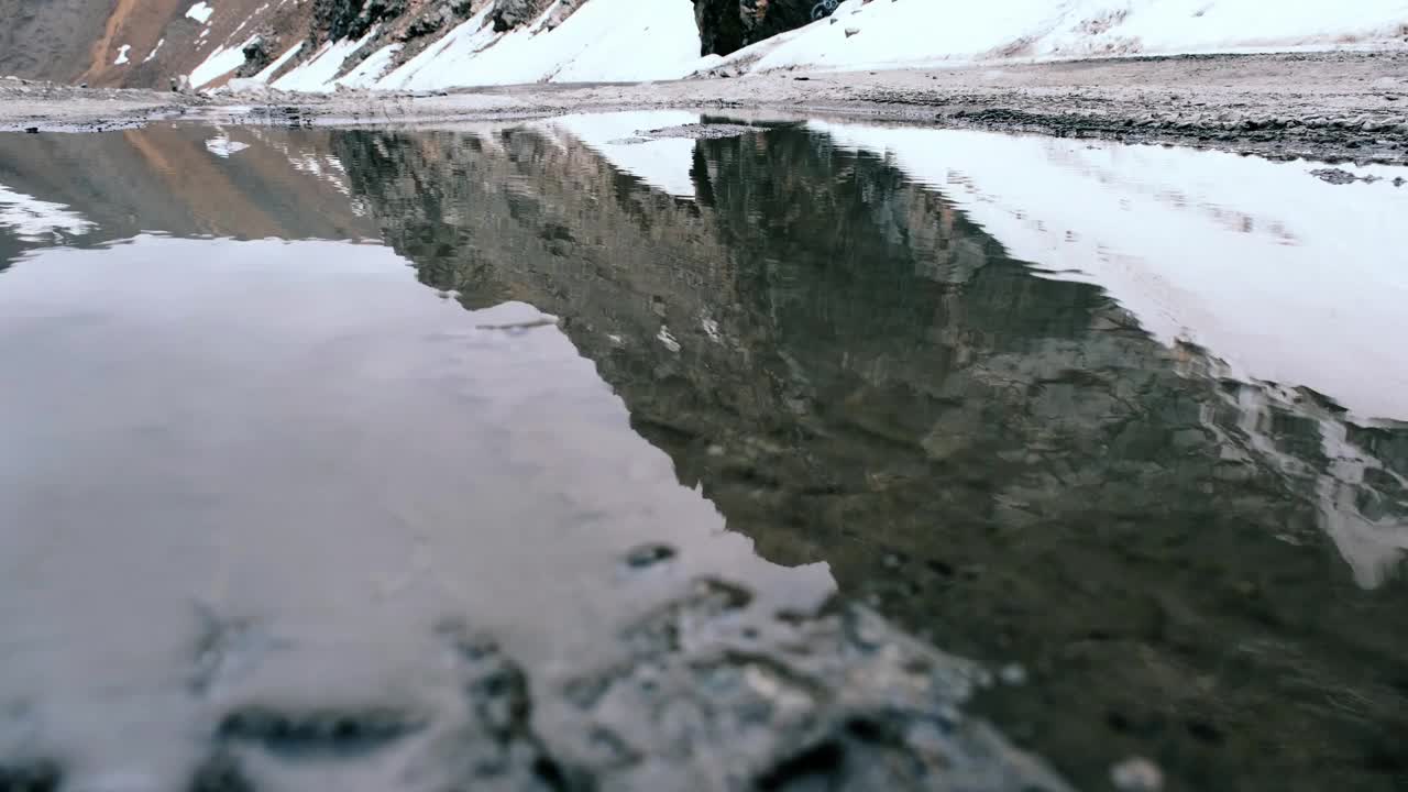 雨后山口的水坑里倒映着阴沉的天空视频素材