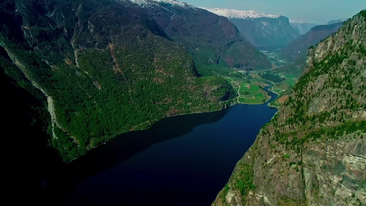 令人叹为观止的奥兰峡湾，周围环绕着高耸的山脉和郁郁葱葱的绿色植物，深蓝色的海水反射着清澈的天空视频素材