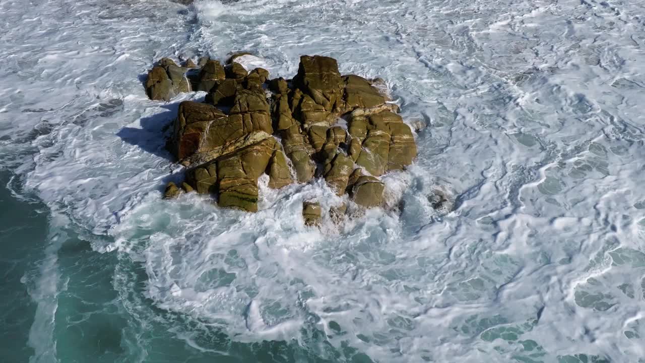 西班牙普拉亚德瓦尔科沃海滩，海浪撞击岩石的慢动作无人机镜头视频素材