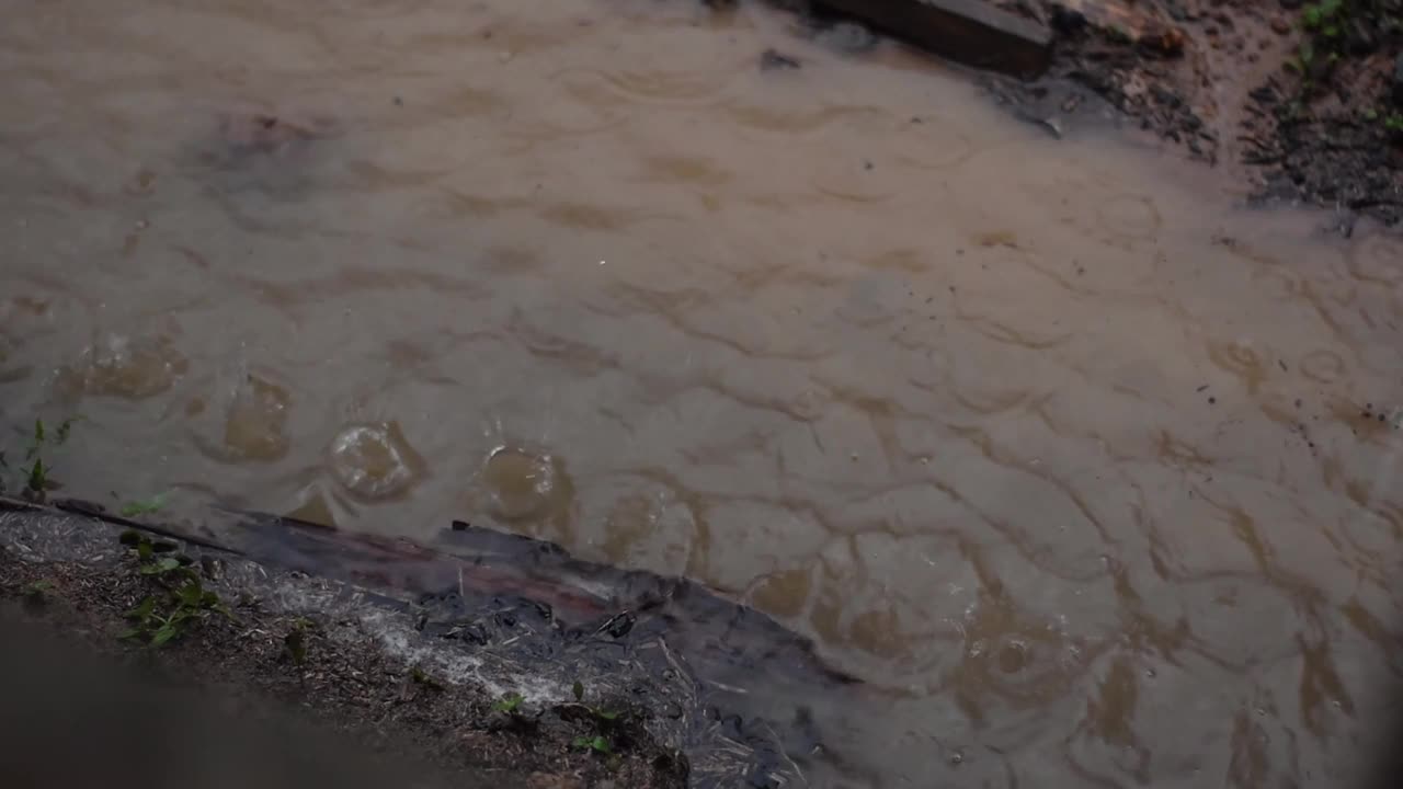 天然地面上的泥泞水坑不断上升，反映出下午下的大雨。视频下载