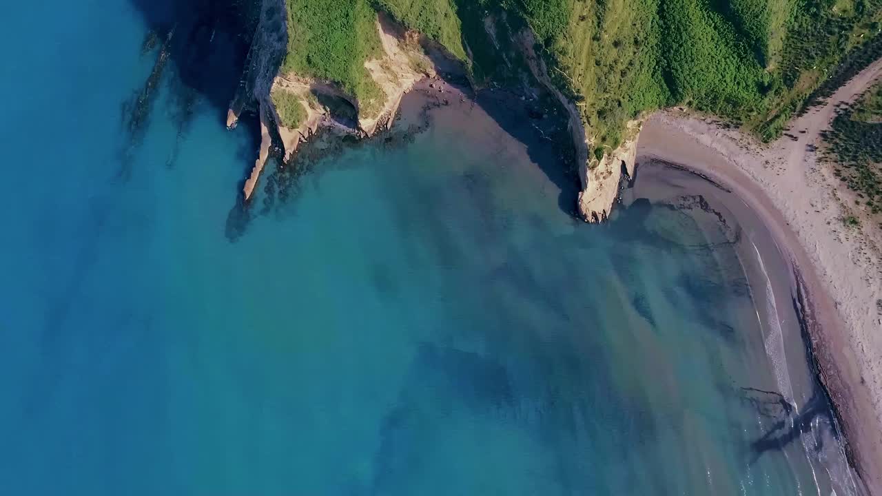 空中海岸景观与郁郁葱葱的悬崖和清澈的蓝色海水，完美的荒野逃生，库页岛视频素材