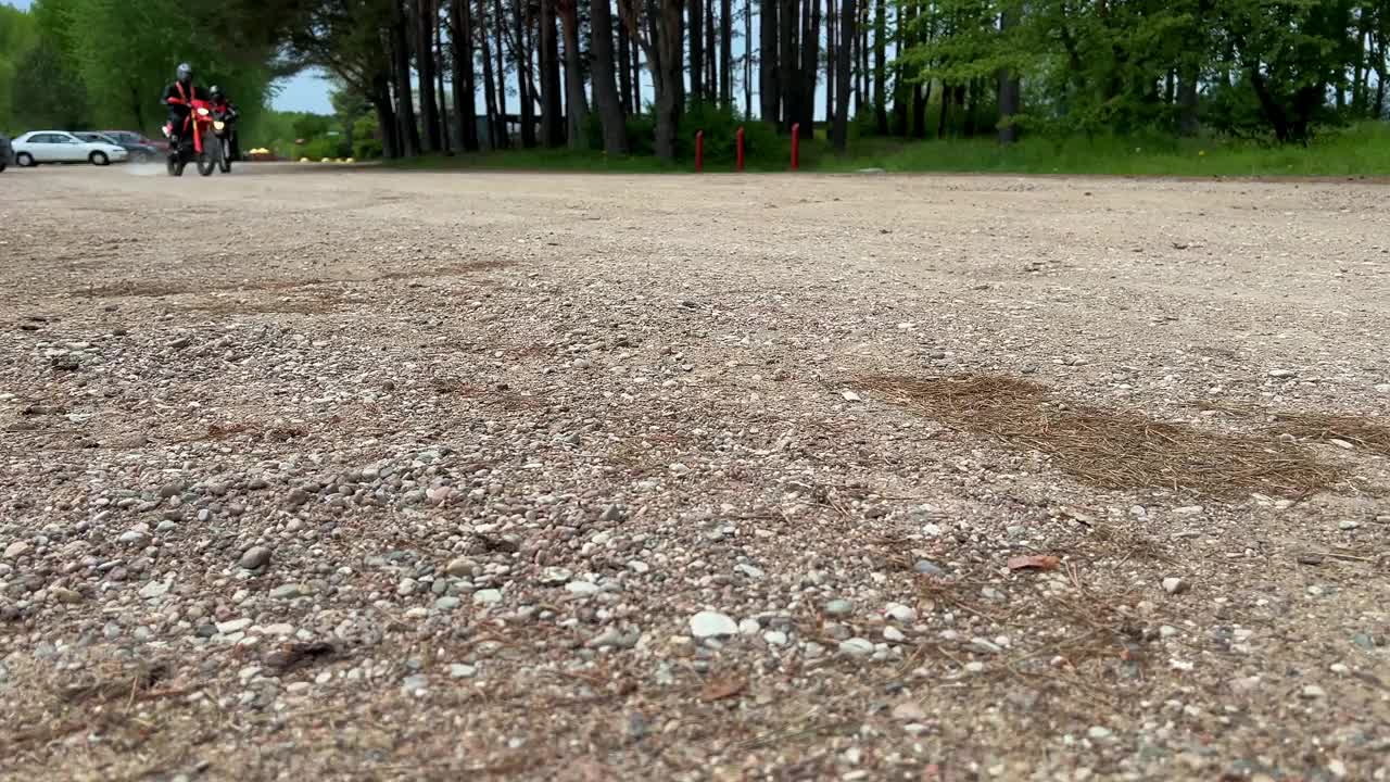 摩托车手骑在森林沙路和绿色的树木为背景视频下载