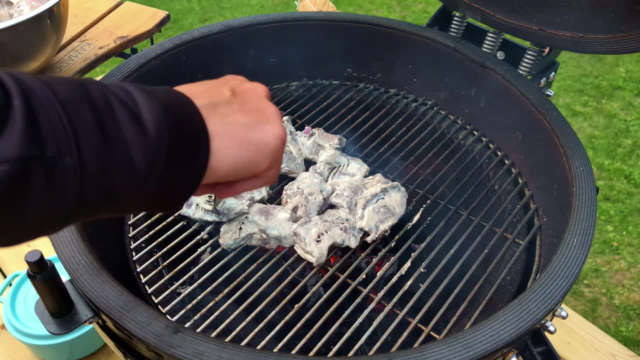 在木炭烤架上煮腌好的肉，蒸汽烟冒出来视频素材