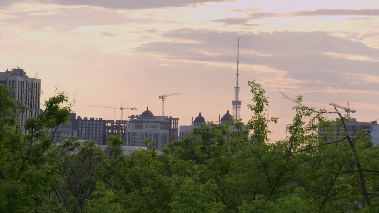 夕阳的天空在基辅的城市，在背景的绿色茂密的树木在乌克兰视频下载