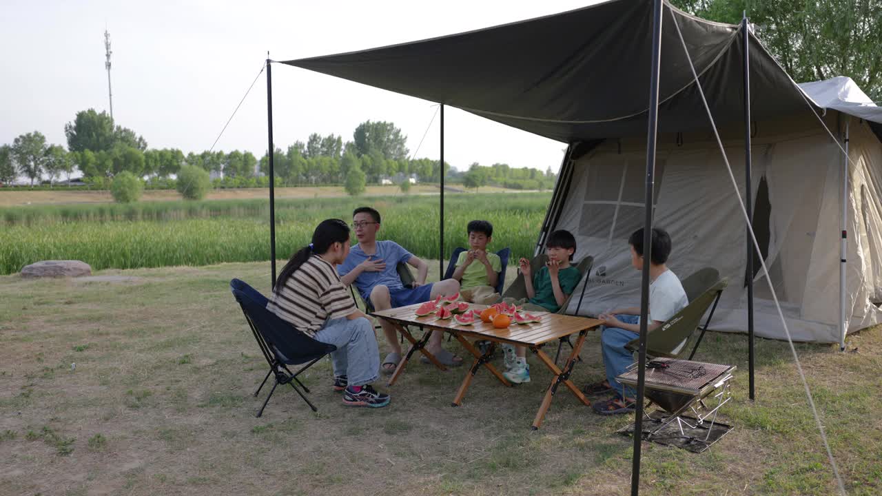 年轻的亚洲父母带着孩子在野外露营视频素材