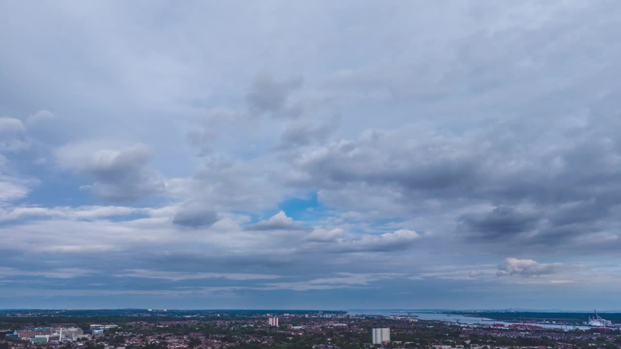 无人机拍摄的云在城市上空的蓝天中移动视频下载