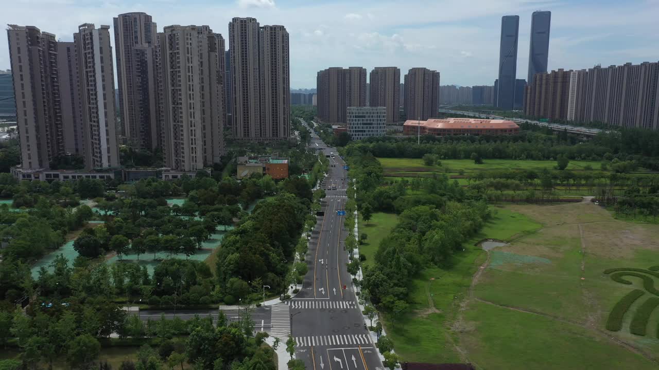 鸟瞰杭州城市的道路，摩天大楼和绿树在中国的白天视频下载