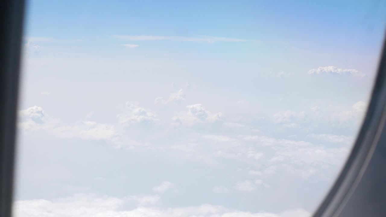 通过飞机的窗户看天空，而飞行飞行旅行旅行在清澈的蓝天和美丽的云视频素材