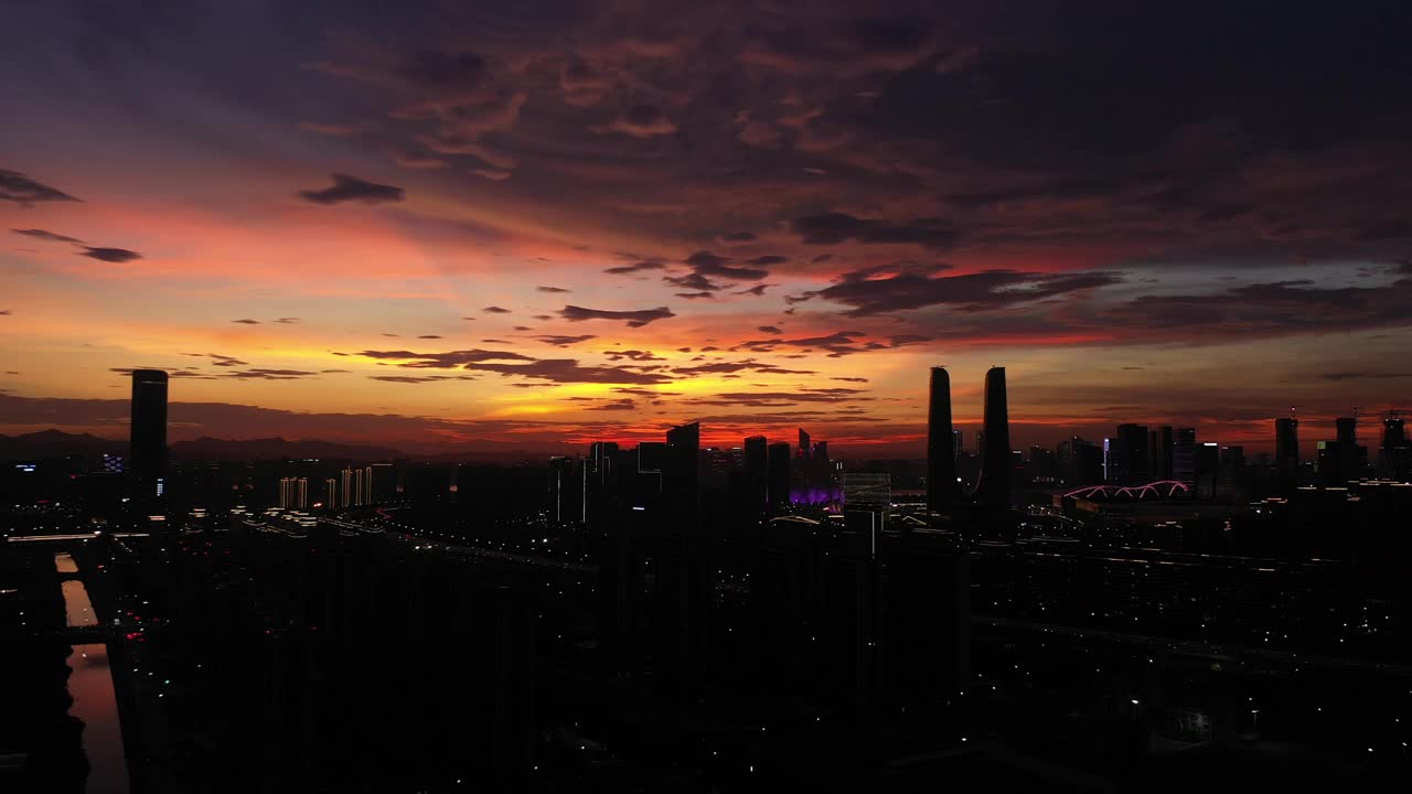 无人机拍摄壮丽的日落天空，令人惊叹的云层笼罩着城市的剪影视频下载