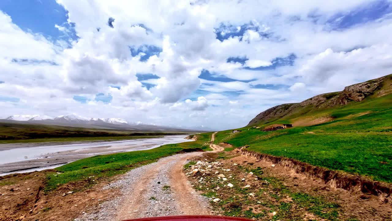 在泥泞的山路上，沿着郁郁葱葱的高河岸，在大河山边旅行视频素材