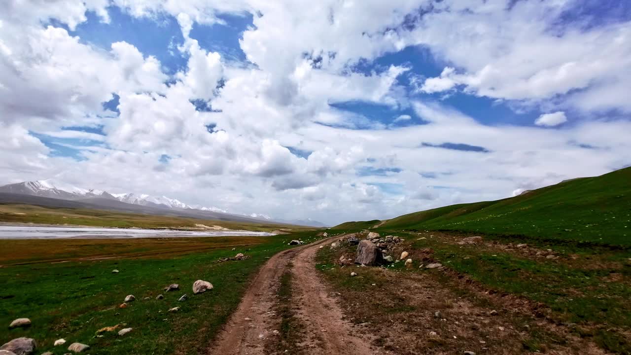 沿着绿油油的高河岸的大河山，在土山路上穿行视频素材