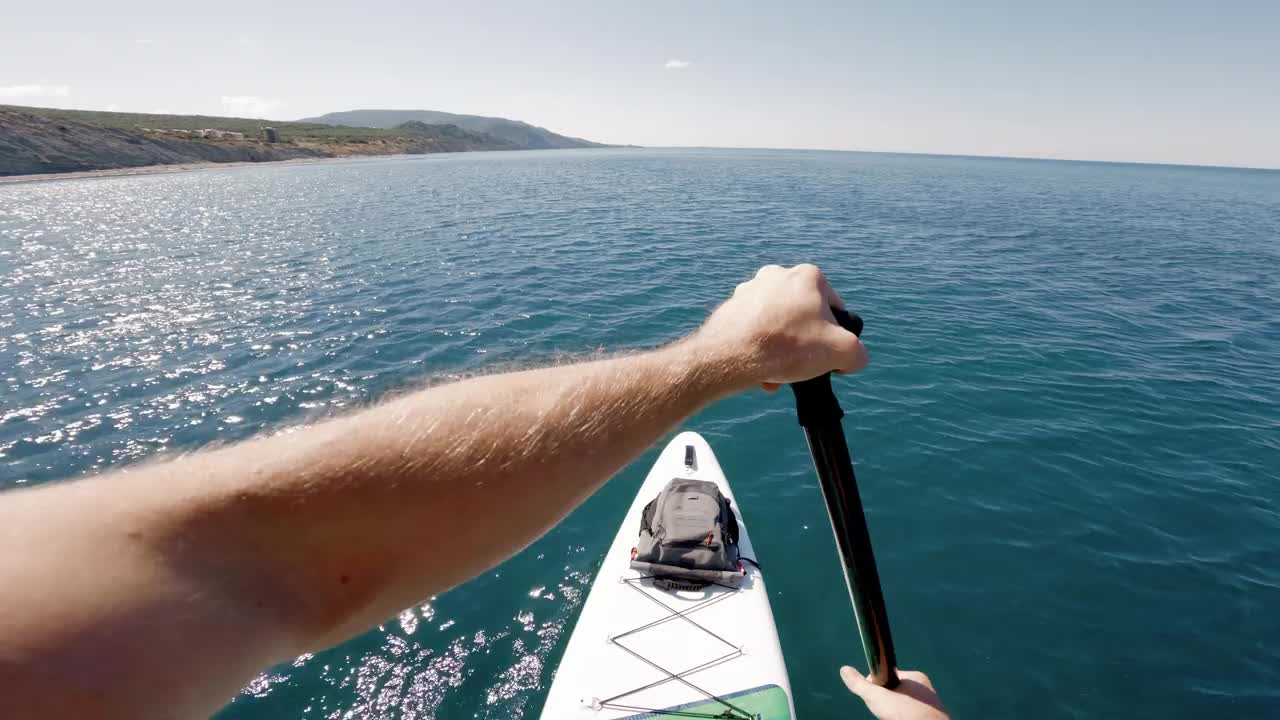 人们在夏日平静的海面上划桨。站桨登船的第一人称视角。视频素材