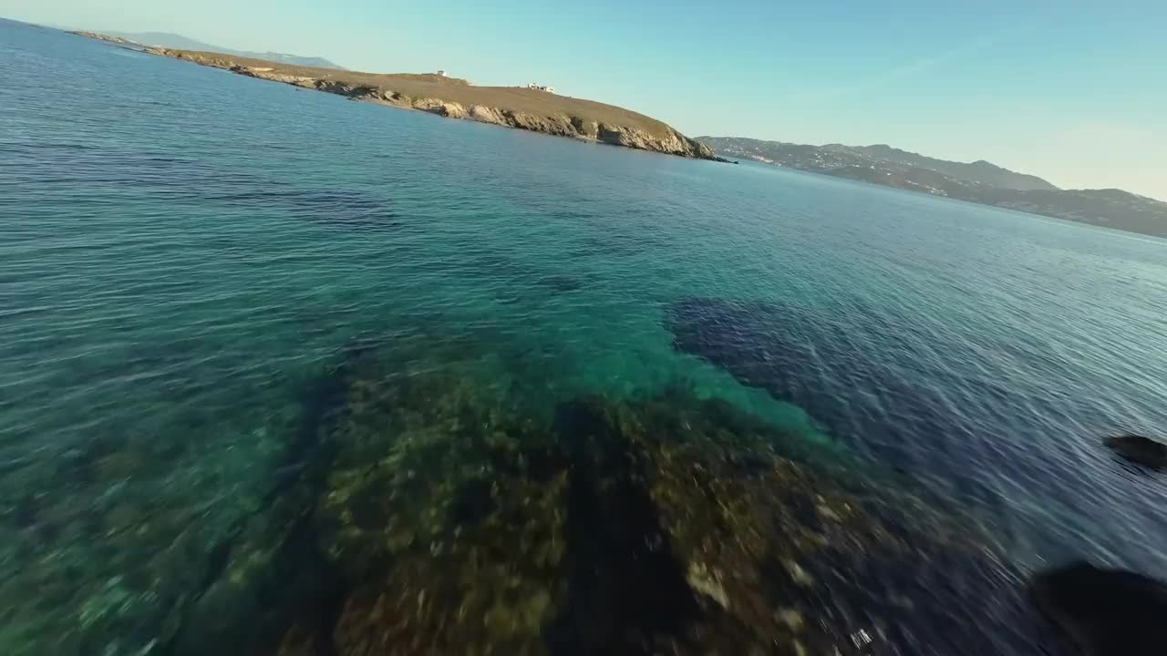 FPV无人机在海上低空飞向希腊的一个岛屿视频素材