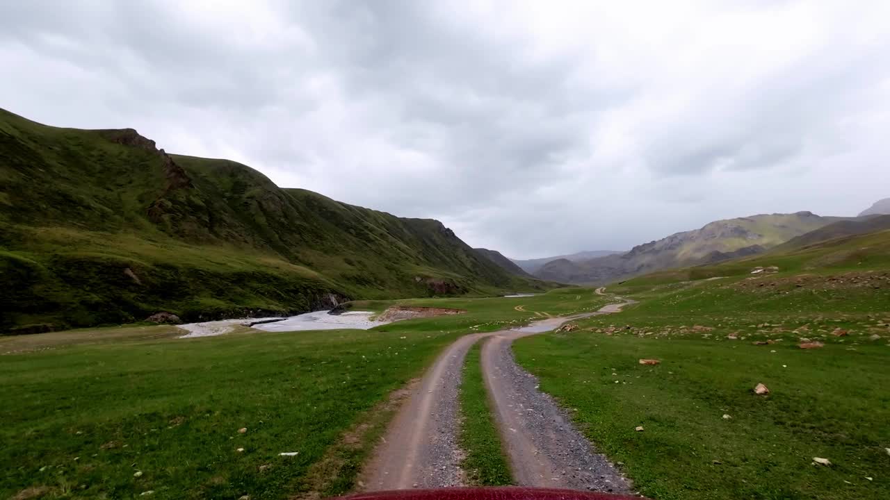 阴雨前的山景。在河边的土石小道上行走视频素材