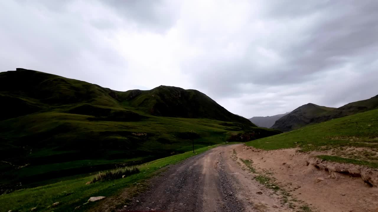 阴森的雨前山景。沿着河岸旁崎岖的土路行进视频素材