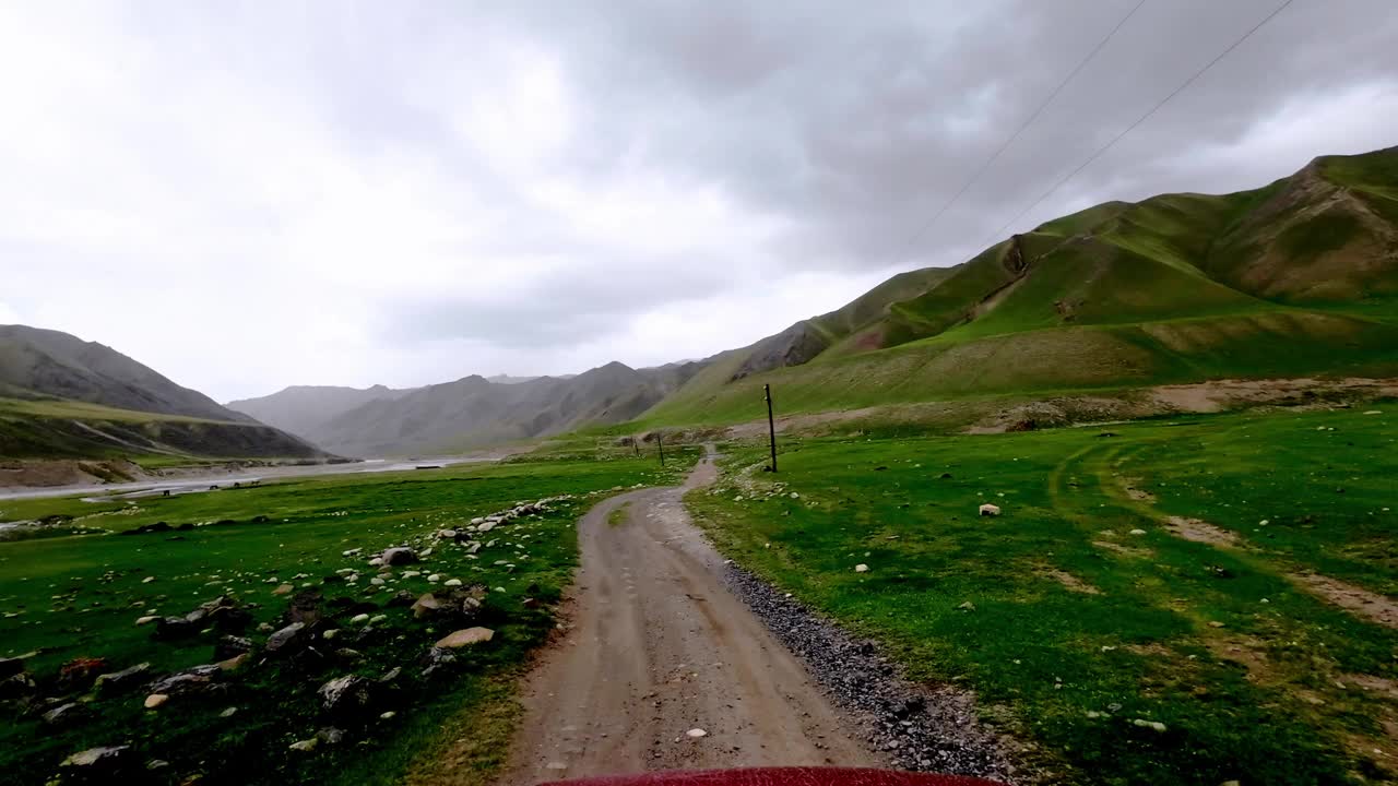 在雨季，群山环绕的绿色牧场中，广阔的山地河谷视频素材