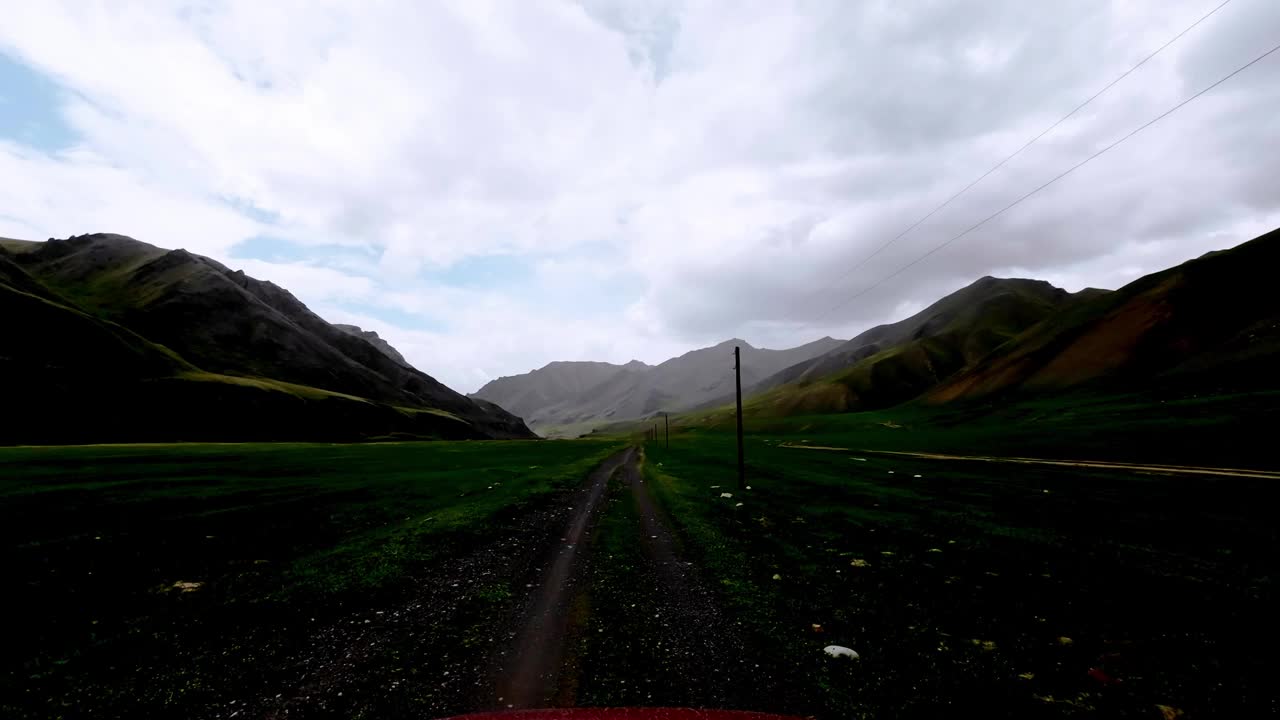 在阴雨的天气里，在群山环绕的绿色牧场之间，宽阔的山河谷视频素材