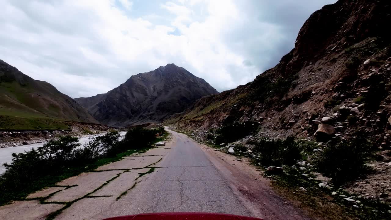 通过紧靠河流和山坡的曲折道路视频素材