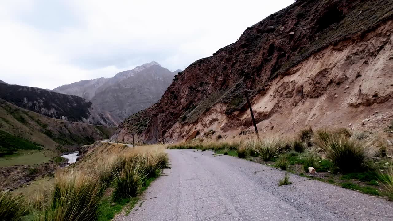 在美丽的天空下，沿着风化的柏油路沿着美丽的峡谷行驶视频素材