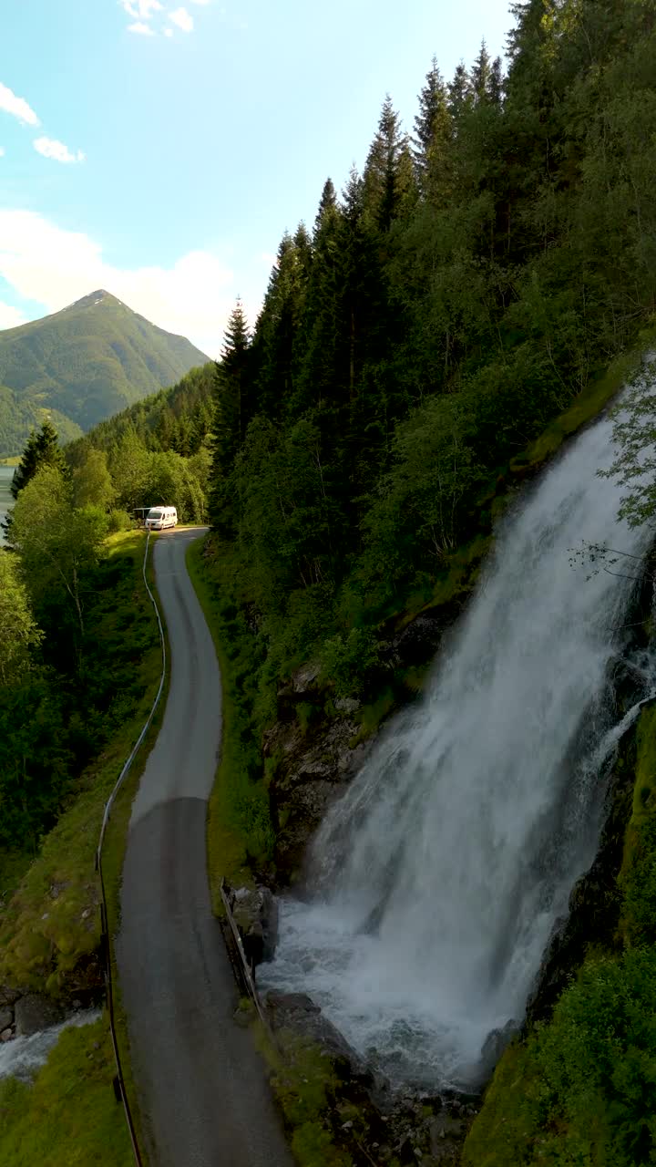 Fjaerlandsfjorden，峡湾，Vestland，挪威，山路与瀑布周围郁郁葱葱的绿色视频素材