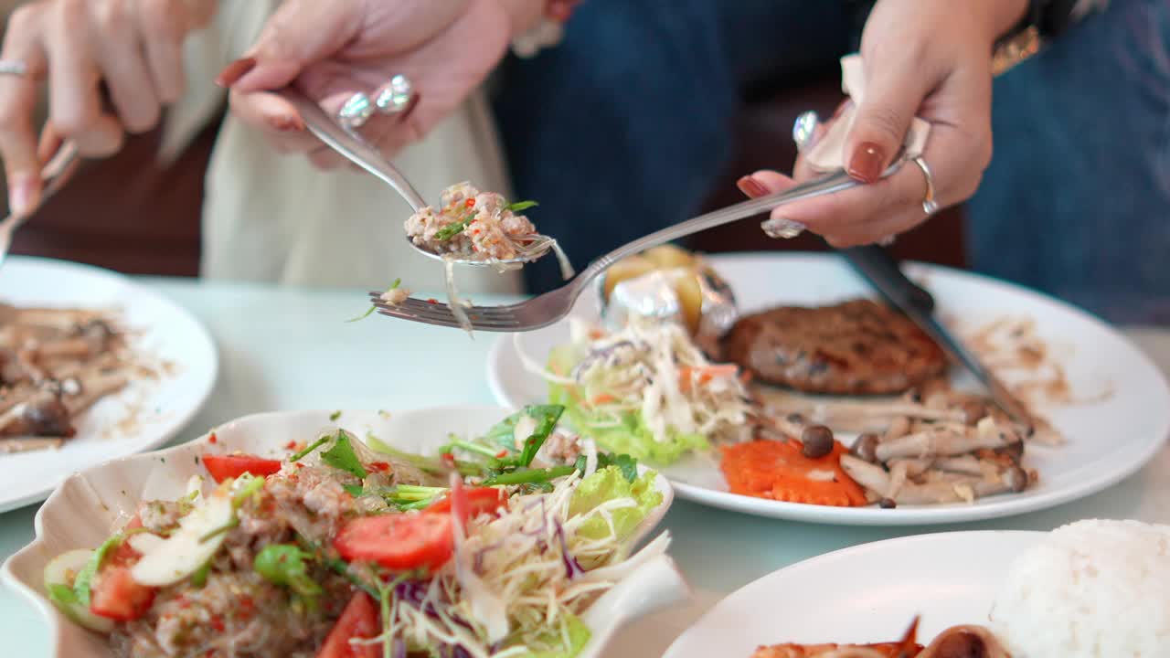 肖像亚洲妇女用勺子舀食物放在餐馆的桌子上，生活方式健康的食物吃享受。视频素材