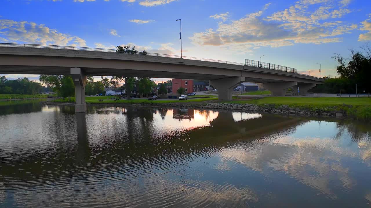 宁静的河水映着桥下日出的天空视频下载