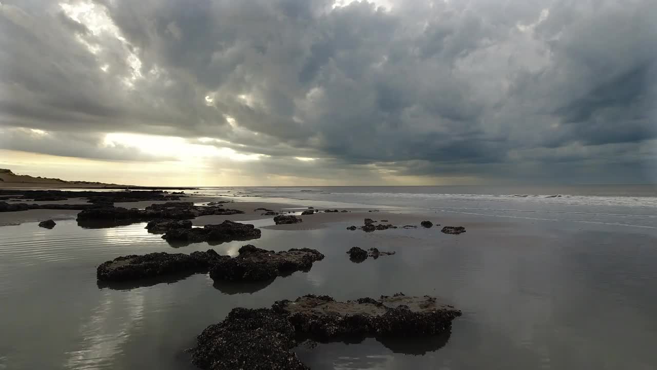 轻松的海滩视频，岩石和软体动物，反射，柔和的海浪，天空与美丽的云。4 k 60 fps视频下载