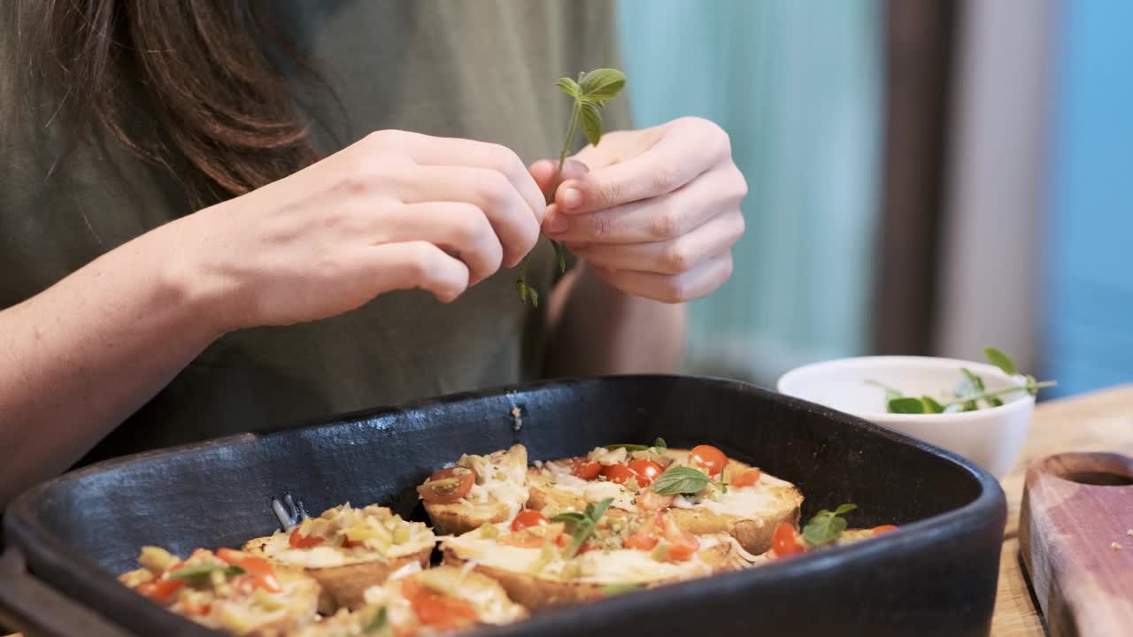 制作意式烤面包时，女性用手放置罗勒的细节视频下载