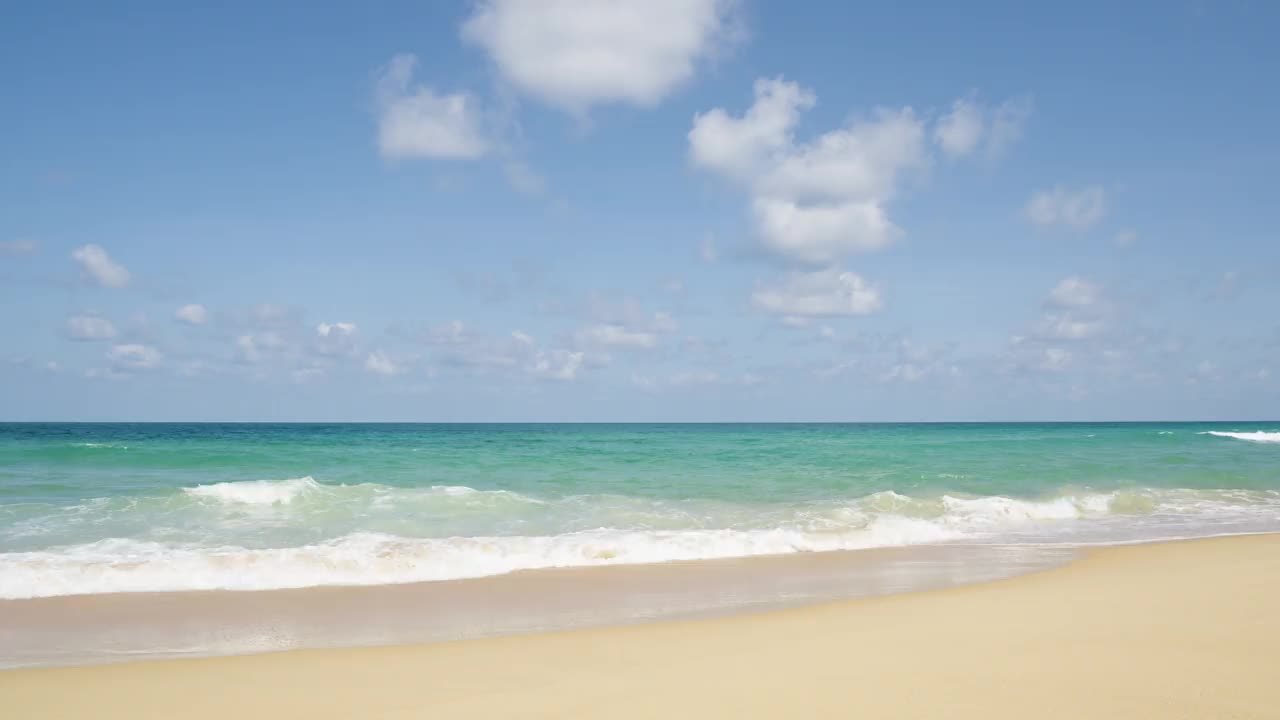 全景视图海滩蓝色的天空波浪大海飞溅沙夏天。视频下载