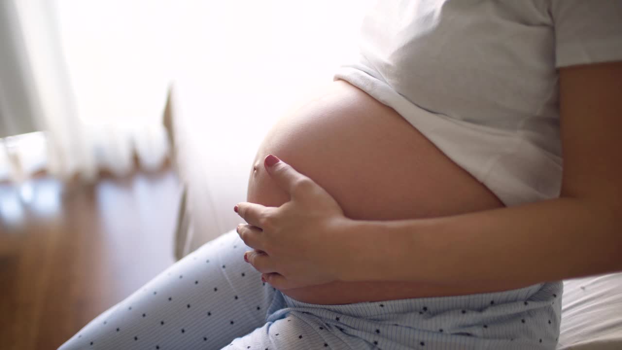 怀孕的最后一天，孕妇抚摸着自己圆圆的肚子视频下载