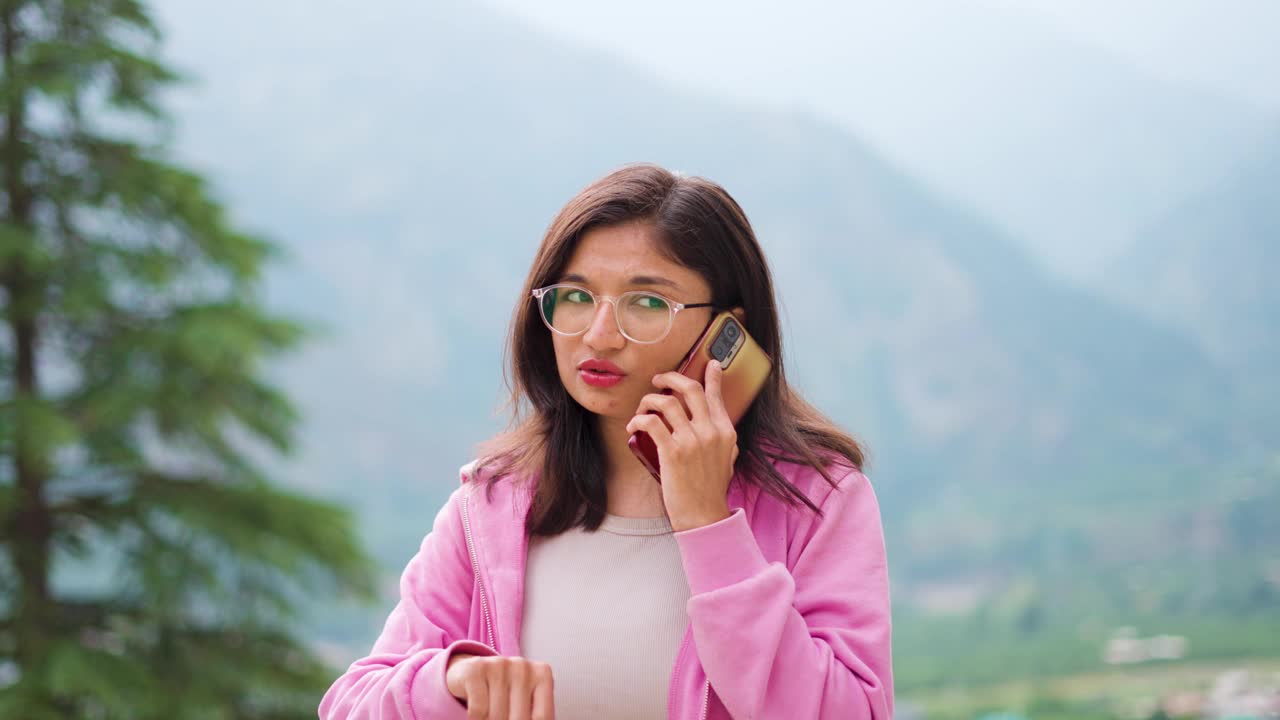 4K拍摄的十几岁的印度女孩和最好的朋友打电话闲聊。年轻女子随叫随到，与远房亲戚联系。在客厅里聊天和沙发上聊八卦的幽默，放松视频素材