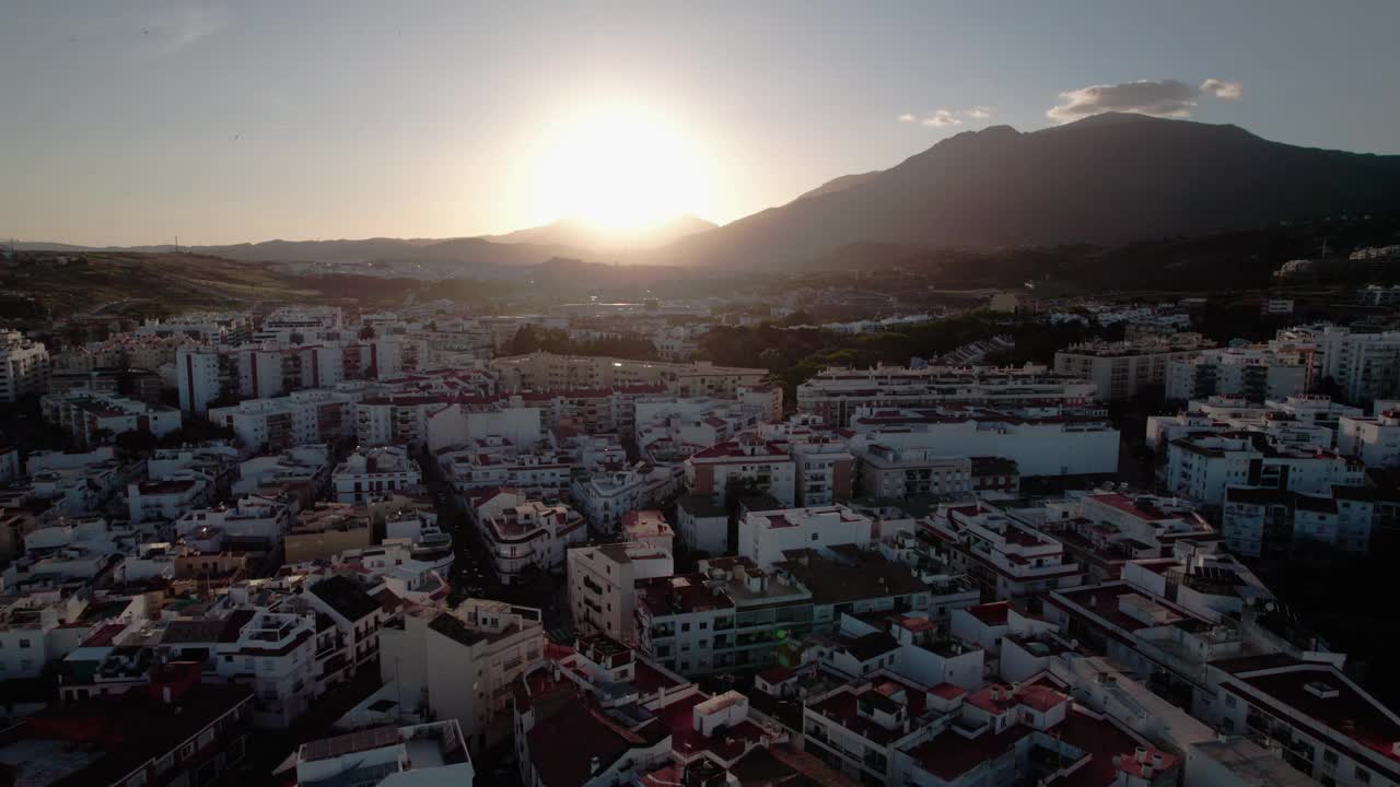 日落时的城市景观，背景为山脉，前景为城市建筑视频下载