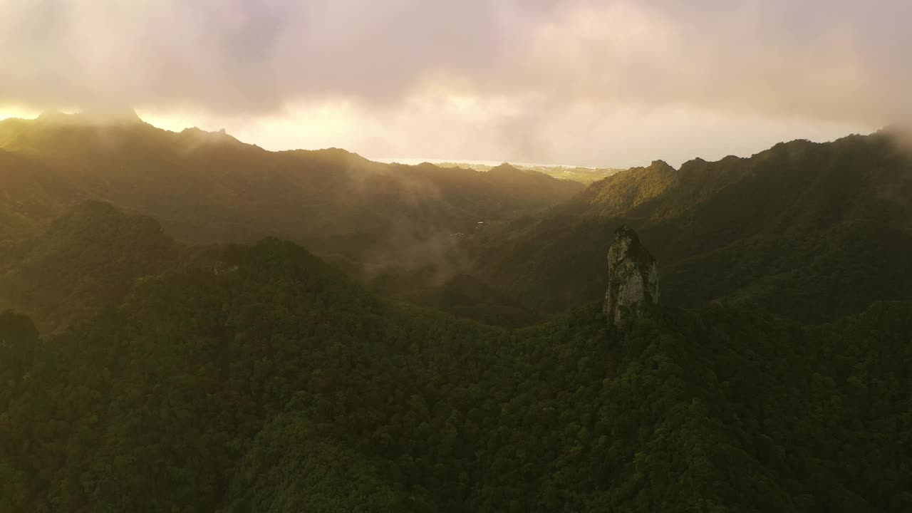 鸟瞰针山山顶，被金色的光覆盖，周围的云逐渐下降。视频下载