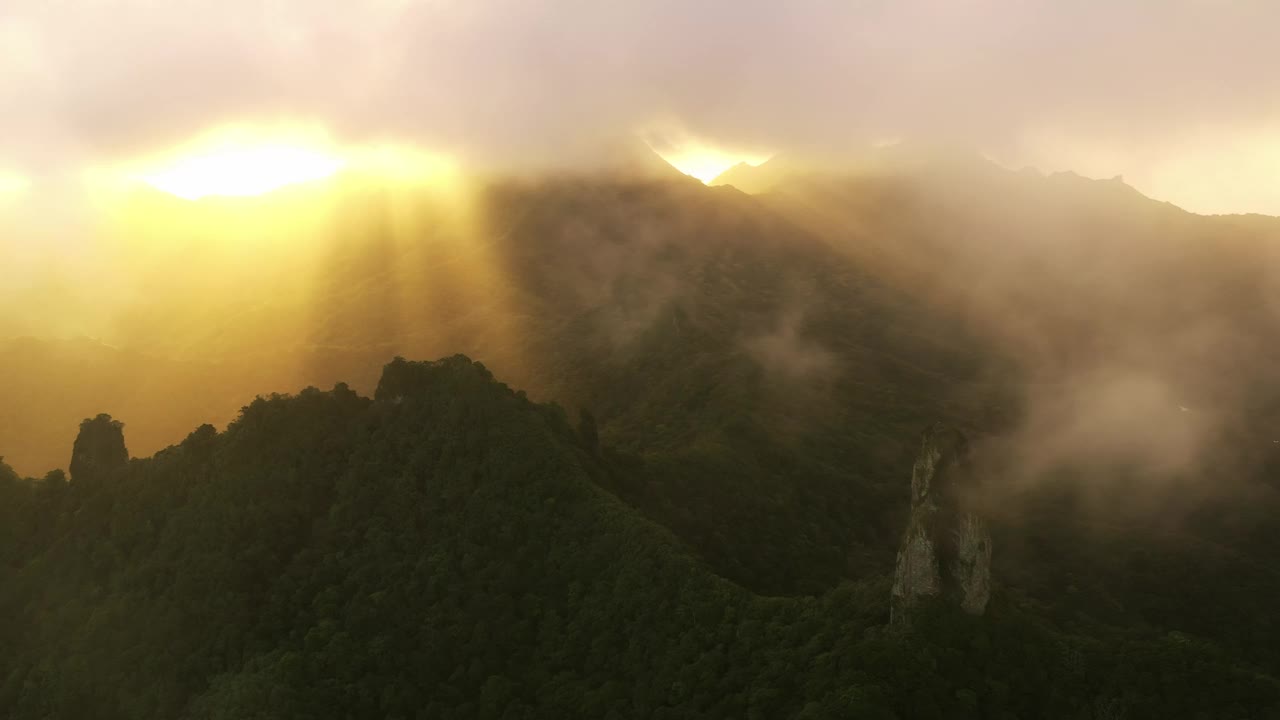 厚厚的云层降落在针山山顶，金色的阳光穿透云层。视频素材