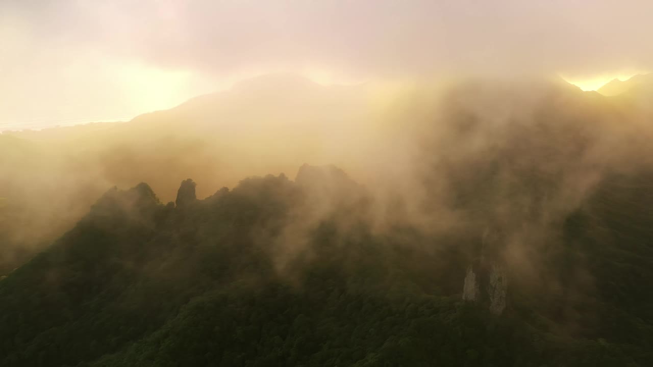 在厚厚的云层和壮丽的金色阵雨的阴影中，可以看到针山高峰。视频素材