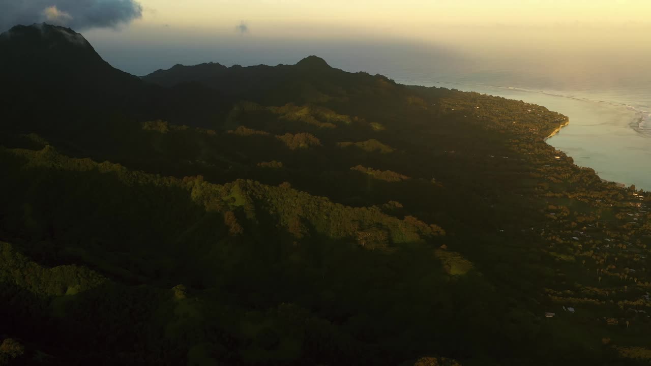 傍晚金色的阳光照射在拉罗汤加岛崎岖的热带山坡上。视频下载