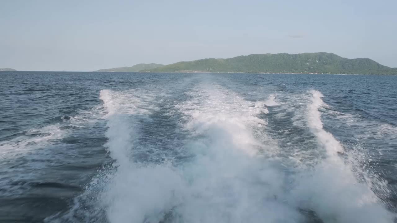 泡沫的痕迹在蓝色的大海上从高速海上摩托艇，旅行概念的背景视频下载