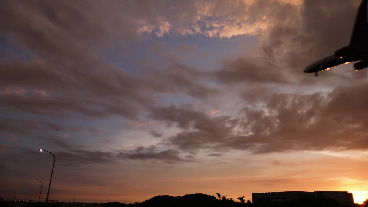 夕阳下飞机降落的剪影视频素材