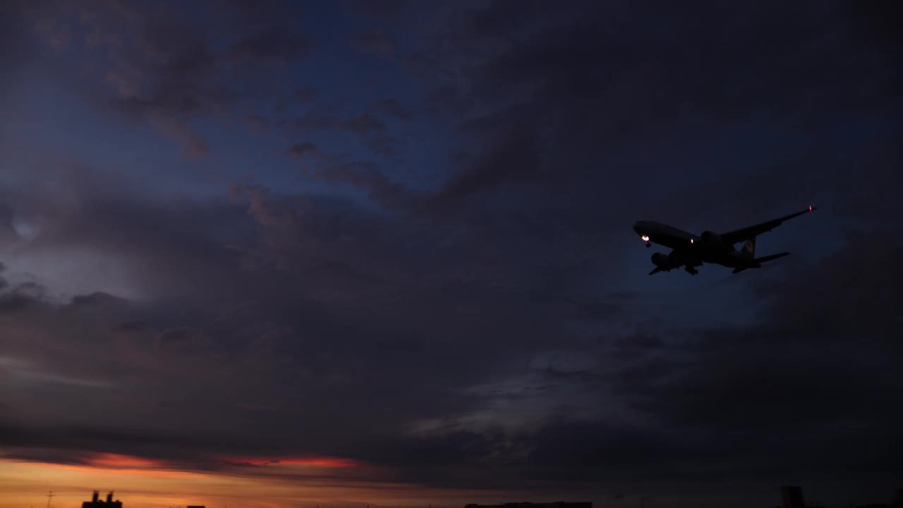 夕阳下飞机降落的剪影视频素材