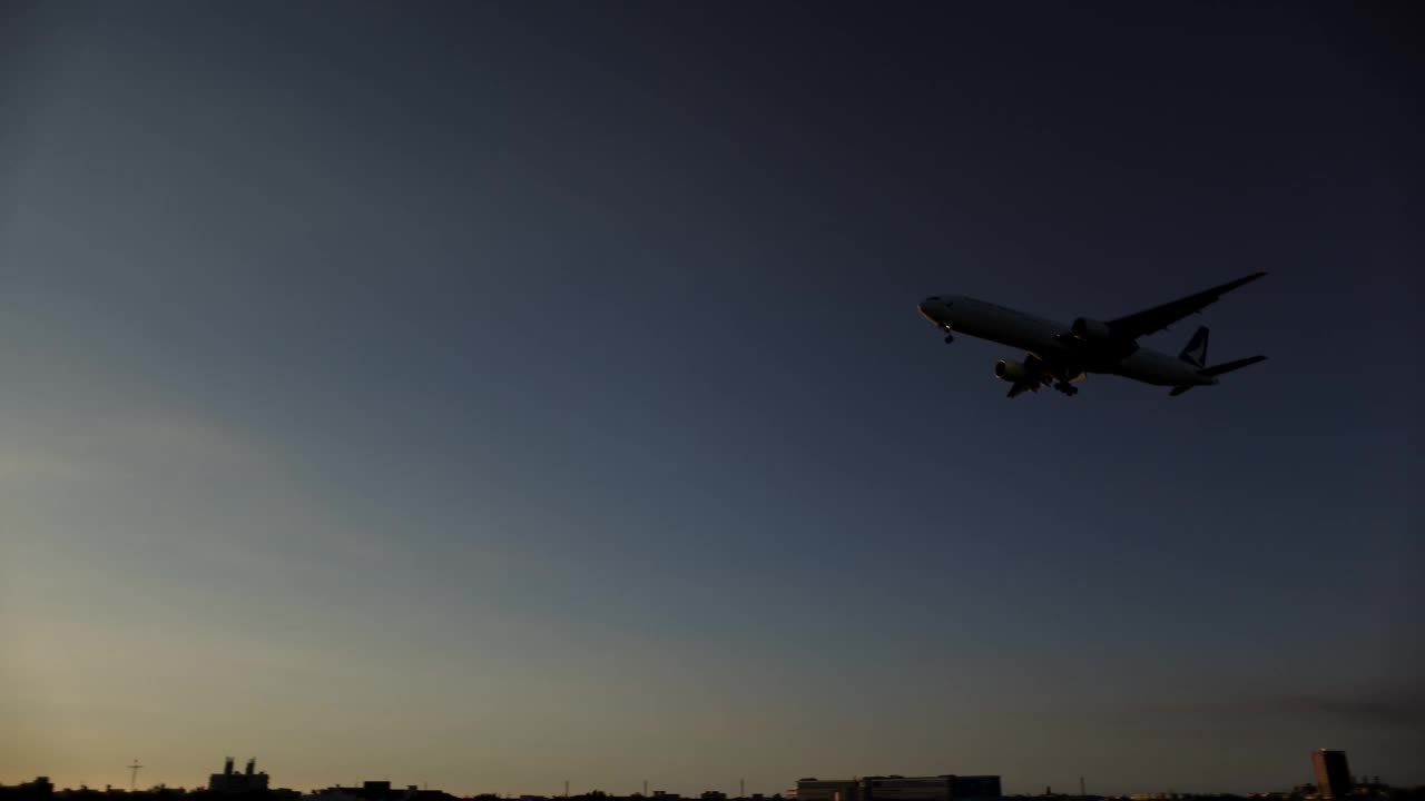 夕阳下飞机降落的剪影视频下载