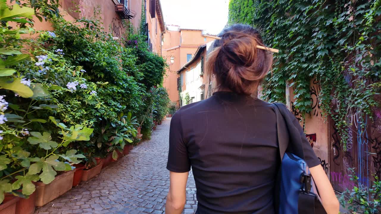 年轻女子在罗马市中心一条舒适的街道上散步视频下载