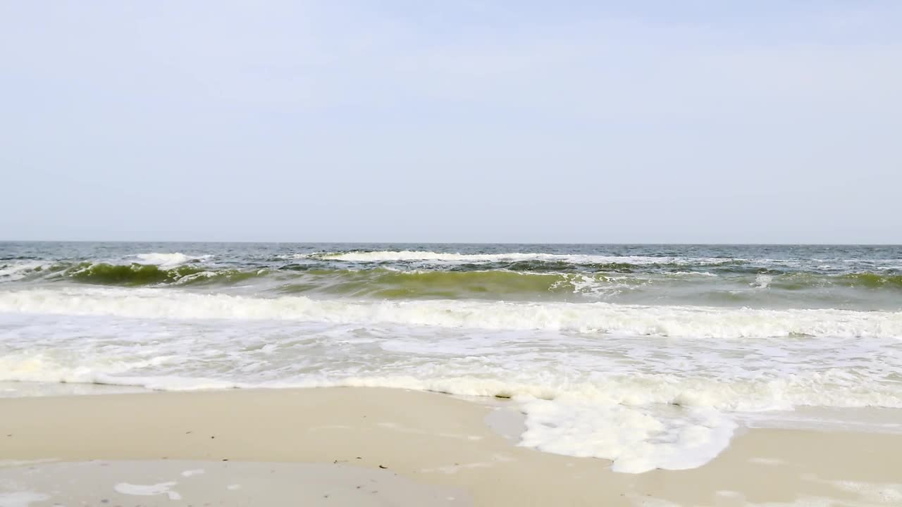 暴风雨的海浪在阳光明媚的天空沙滩镜头视频素材