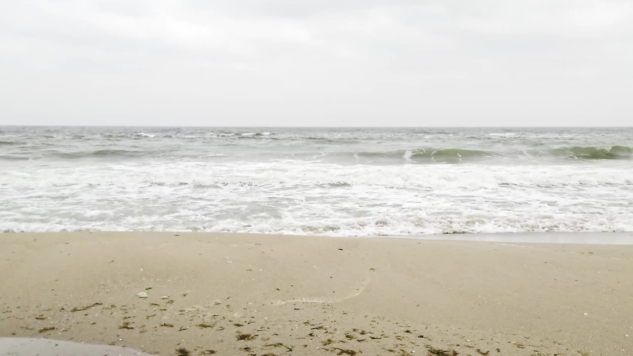 波涛汹涌的海滩和多云的灰色天空视频素材